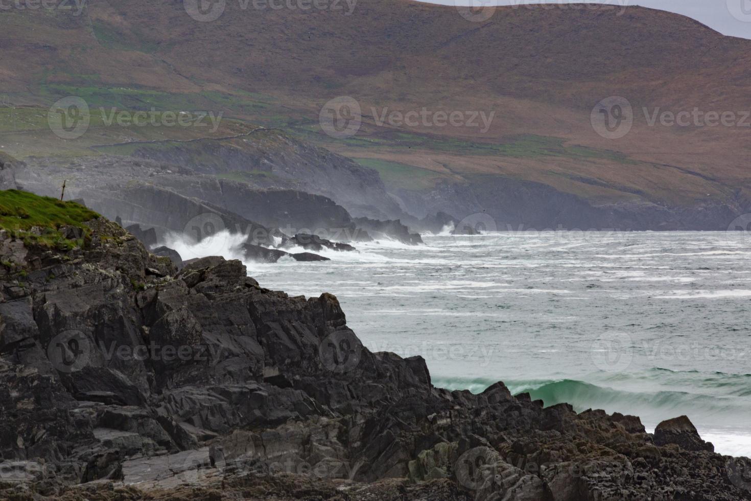 Rough breaking of waves on Irish coast line during daytime photo