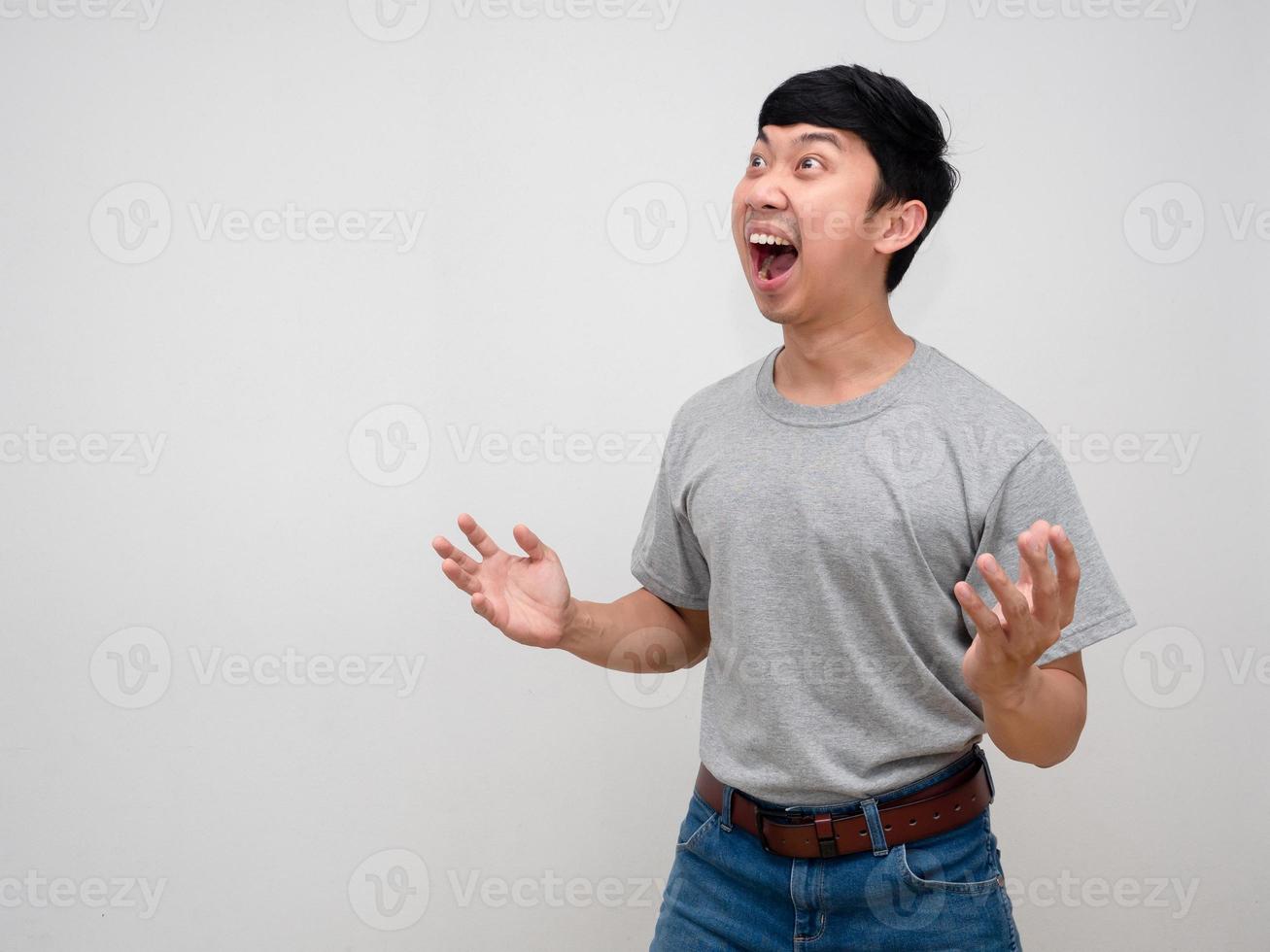 hombre asiático camisa gris gesto de pie asombrado se siente conmocionado aislado foto