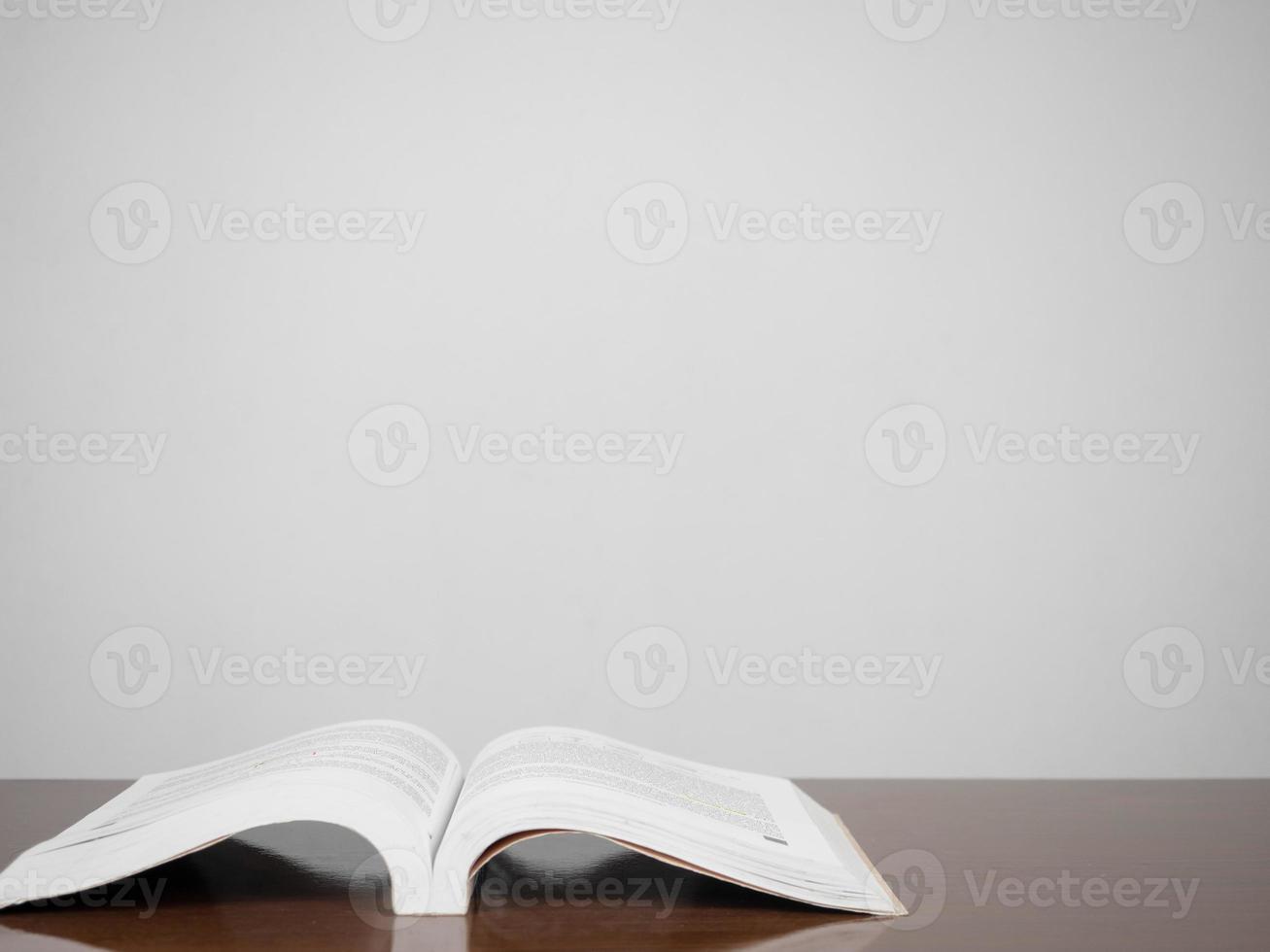 libro de texto sobre la mesa fondo de pared blanca foto