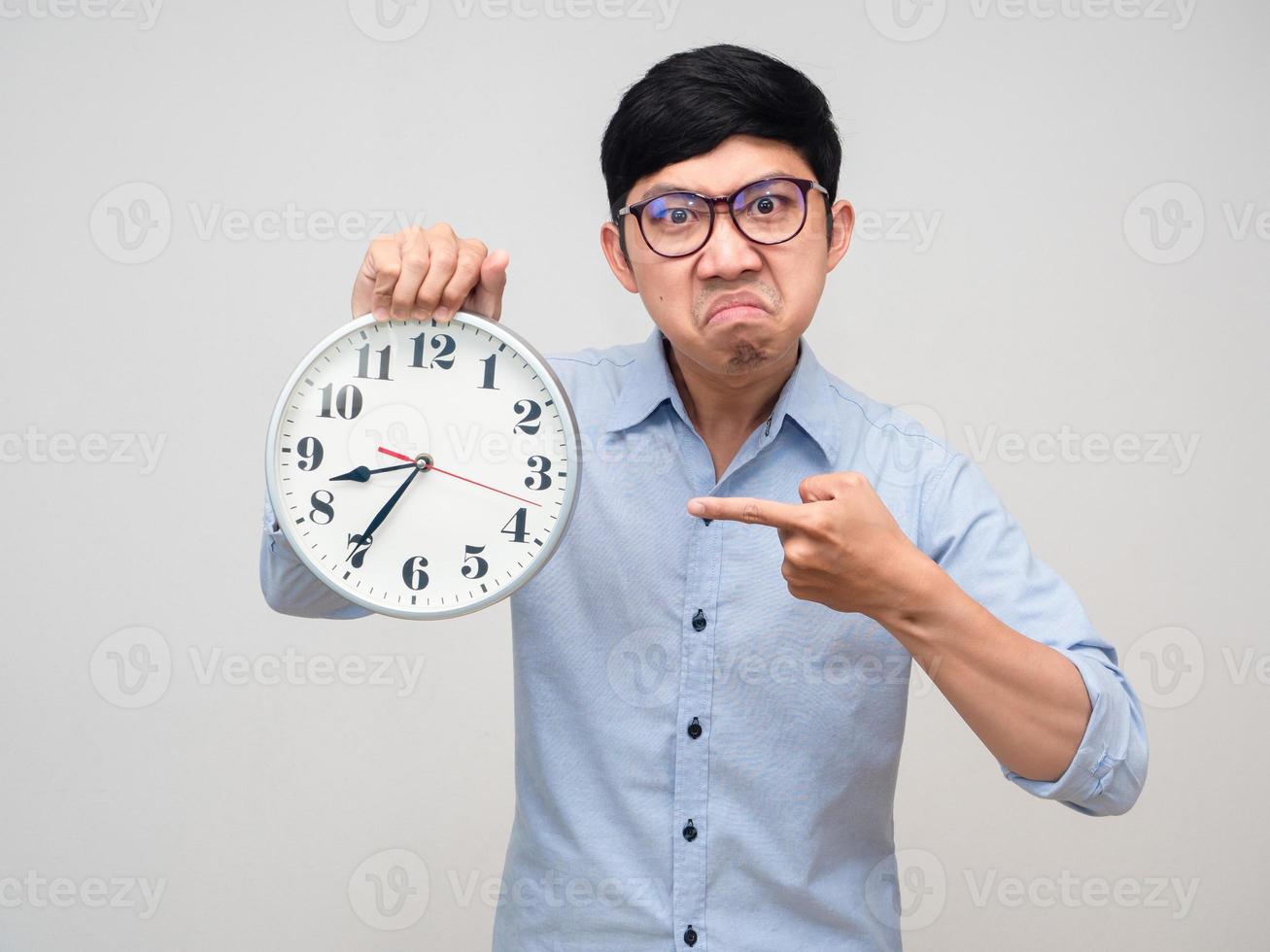 Young manager wear glasses angry emotion point finger at analog clock isolated photo