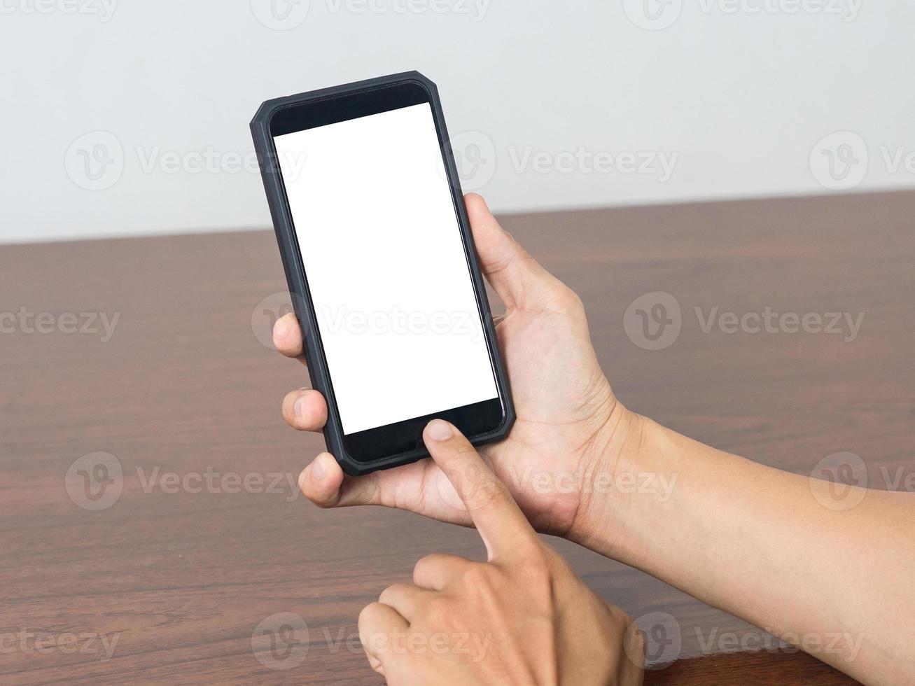 Man hold mobile phone blank white screen mockup on the table photo