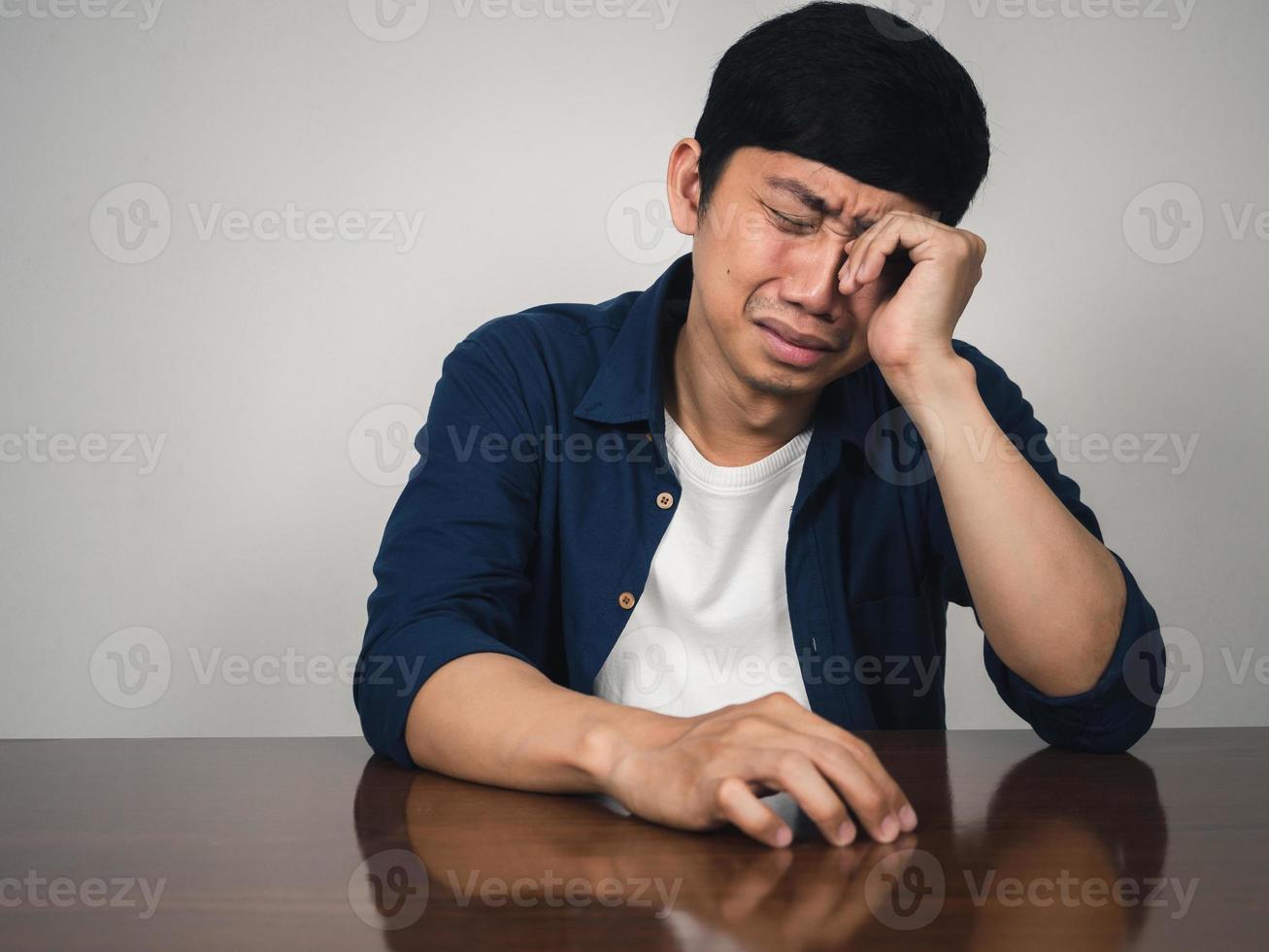 Asian man sit at table feels depressed and sadness and crying about life photo