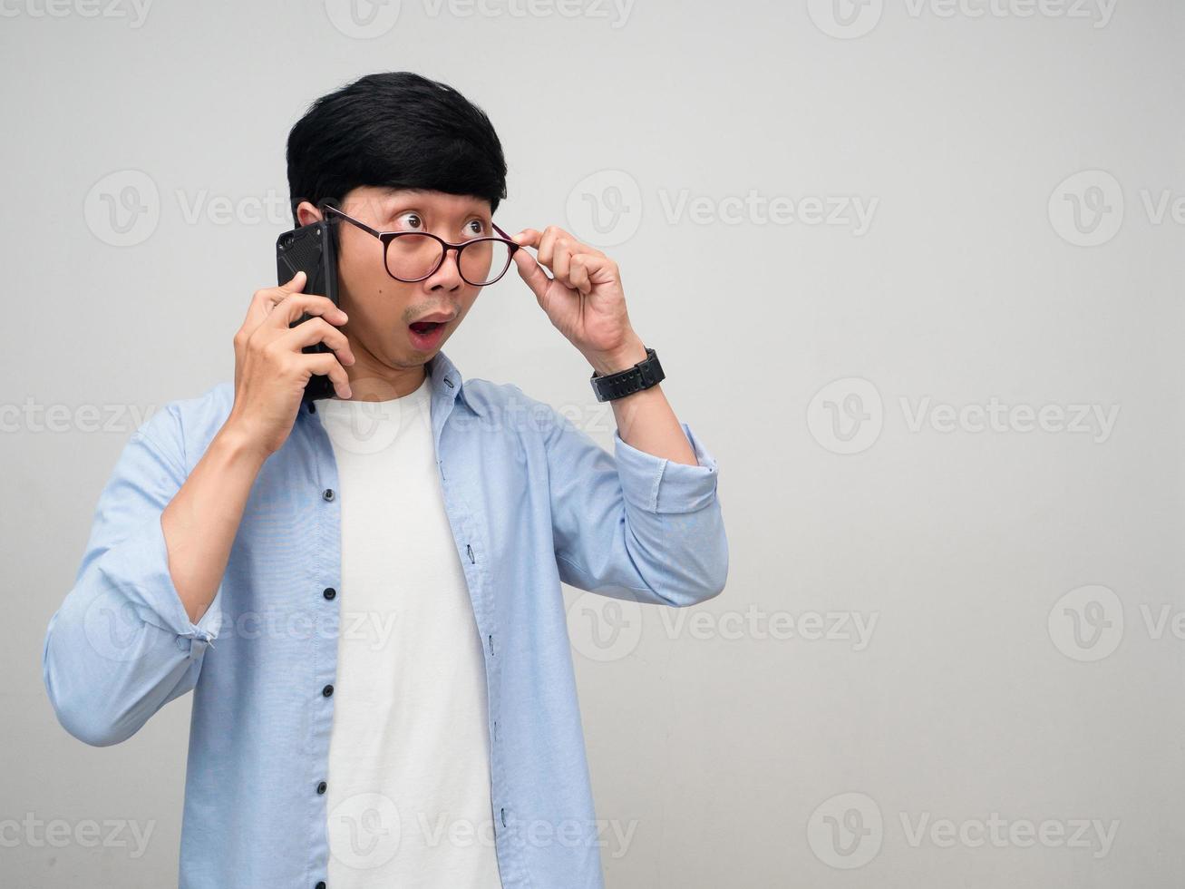 Asian man talking mobile phone gesture take off his glasses to looking isolated photo