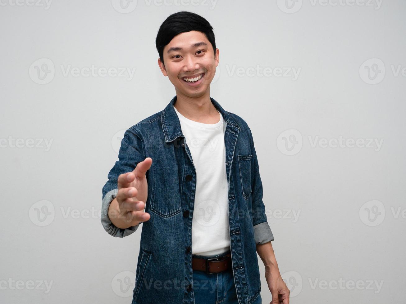 Positive asian man happy smile jeans shirt gesture hand shake isolated photo