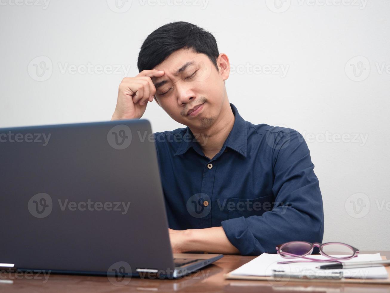 Male employee sit at working table feels tried with work photo