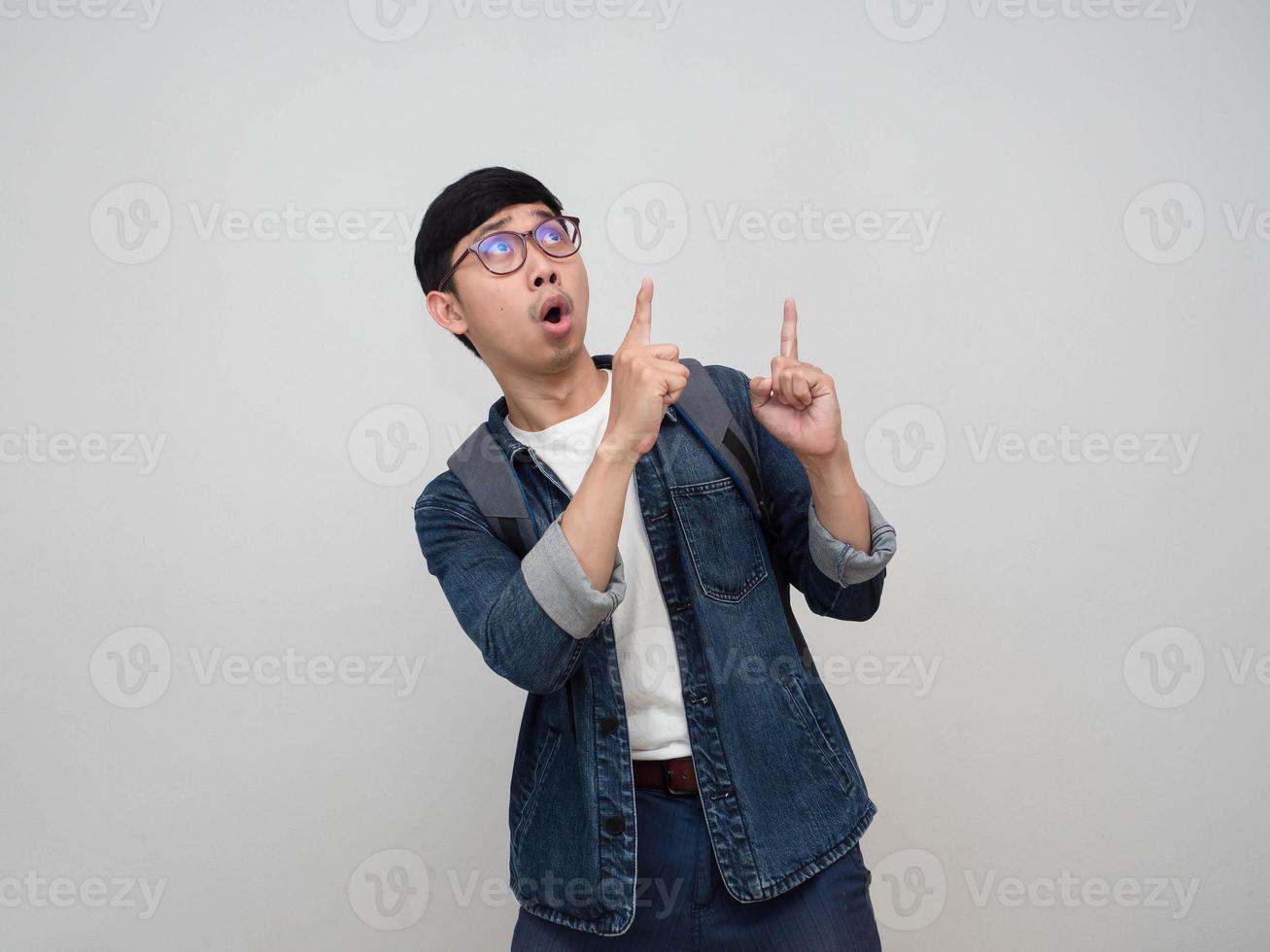Cheeful hombre asiático jeans camisa usar gafas se siente sorprendido gesto señalar con el dedo aislado foto