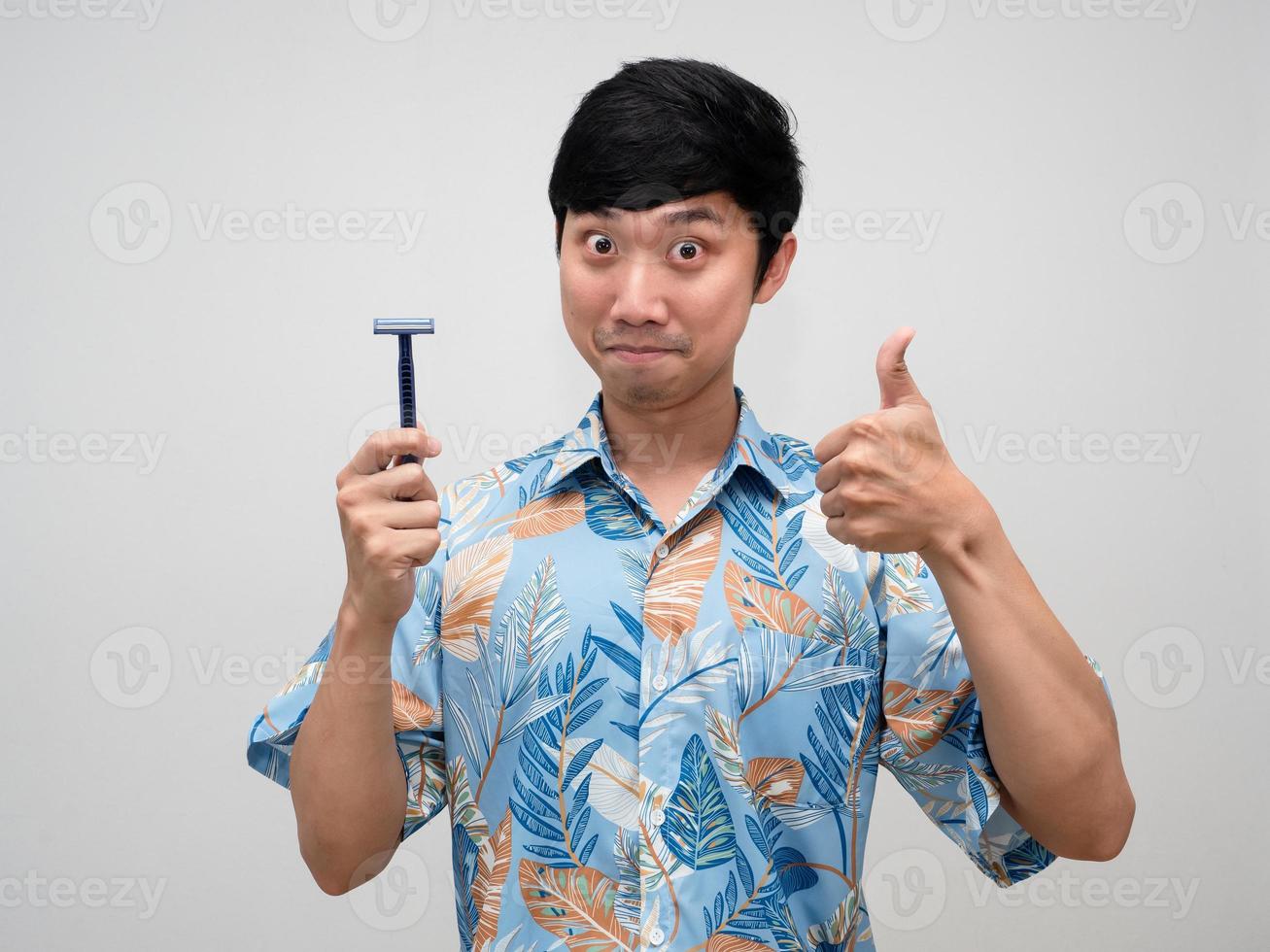 Positive asian man blue shirt holding shaving show thumb up isolated photo