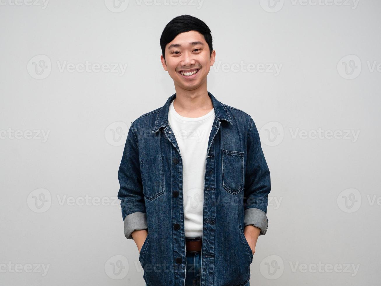 Positive asian man jeans shirt happy smile standing push hands in shirt pocket isolated photo