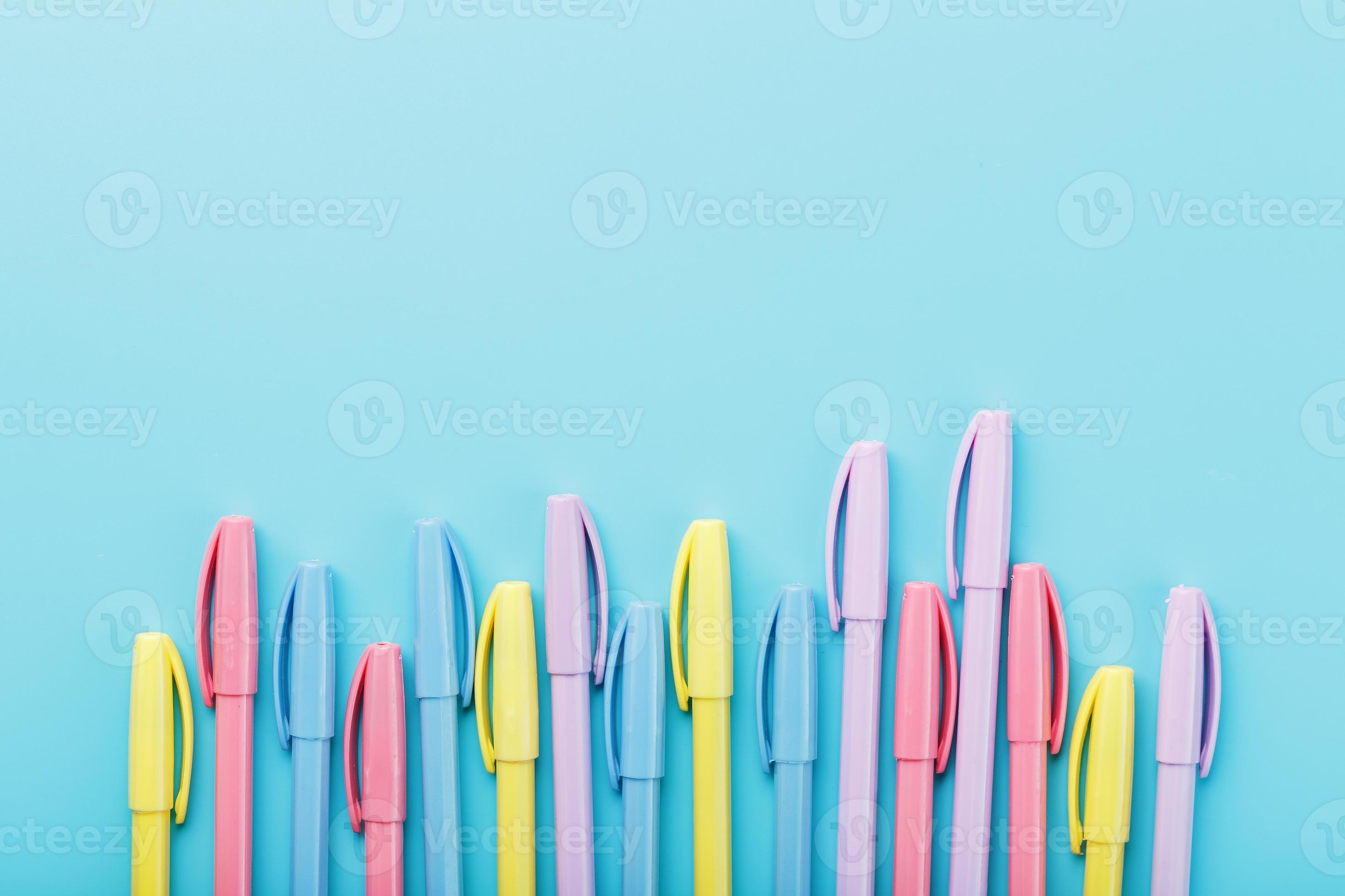 Multi-colored pens on a blue background with free space. 17072084 Stock  Photo at Vecteezy