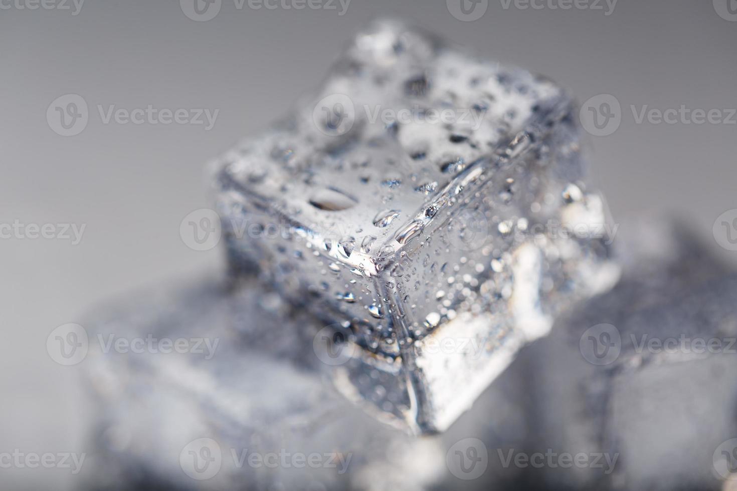 Ice cube with water drops close - up in macro on a white background. Refreshing ice. Isolate photo