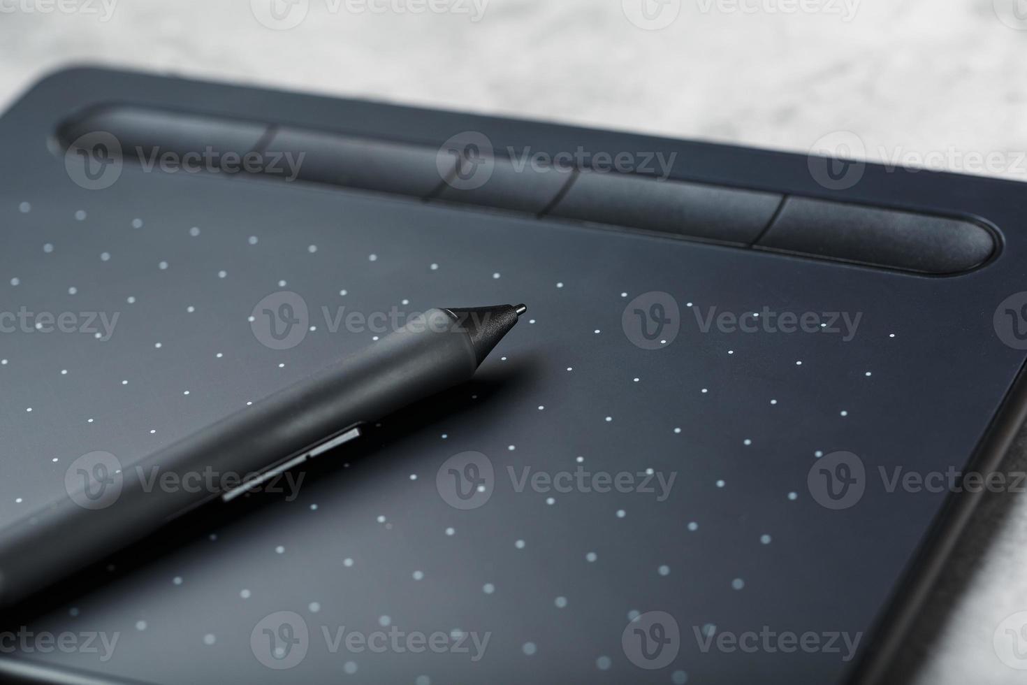 pluma con una tableta gráfica en manos del diseñador, primer plano. gadget para el arte y el trabajo. foto