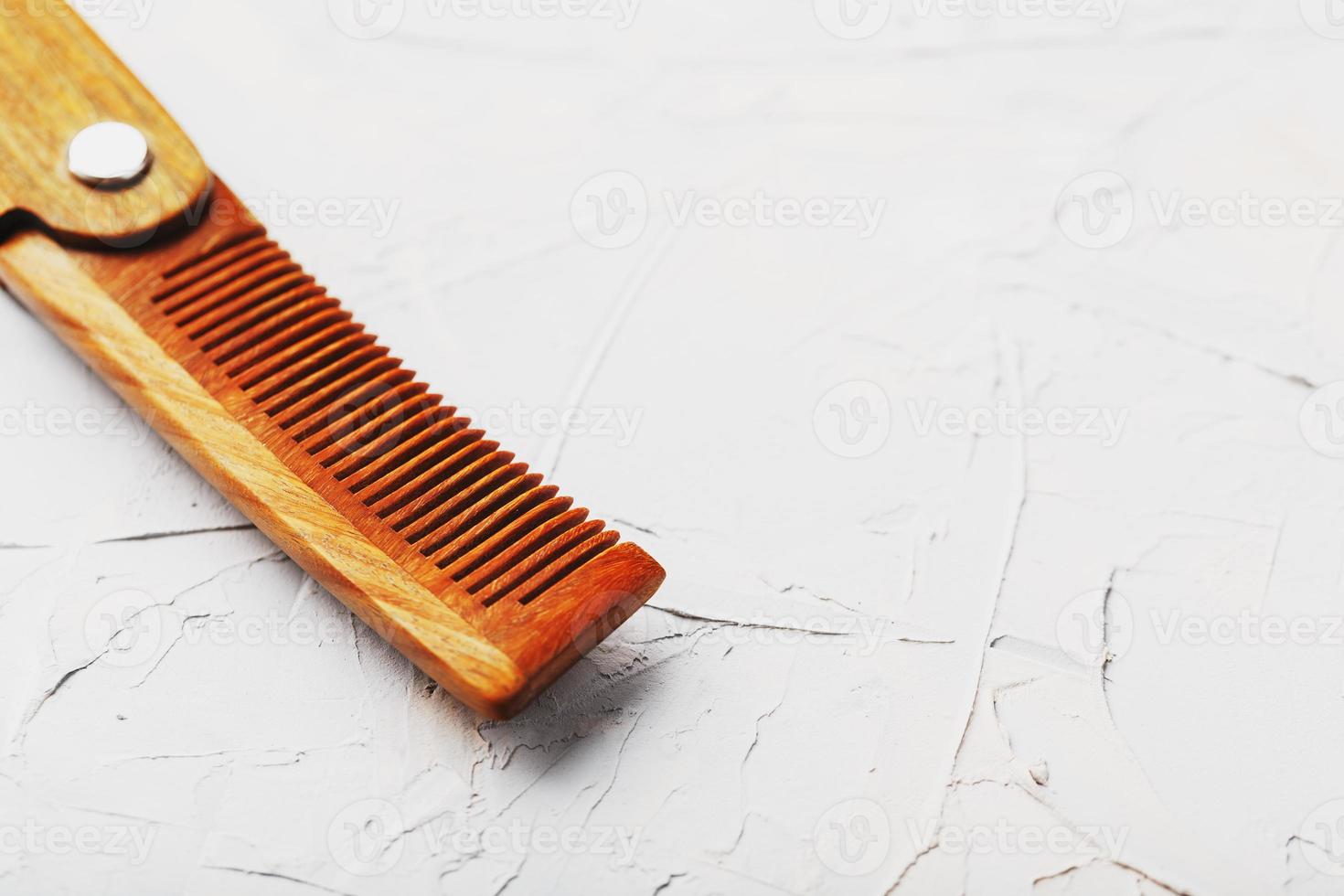 Folding wooden comb on a gray background. photo