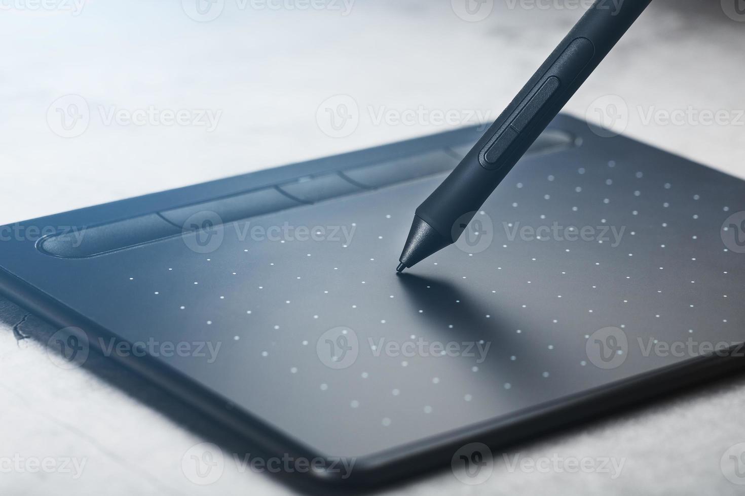 pluma con una tableta gráfica en manos del diseñador, primer plano. gadget para el arte y el trabajo. foto