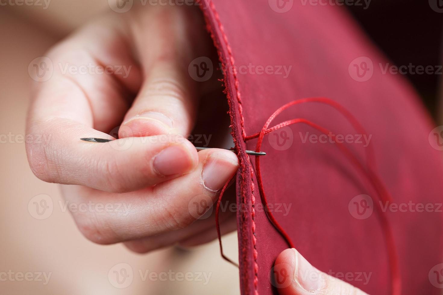 Conceptual profession of a Tanner. The woman's hands closed around the needle and thread. photo