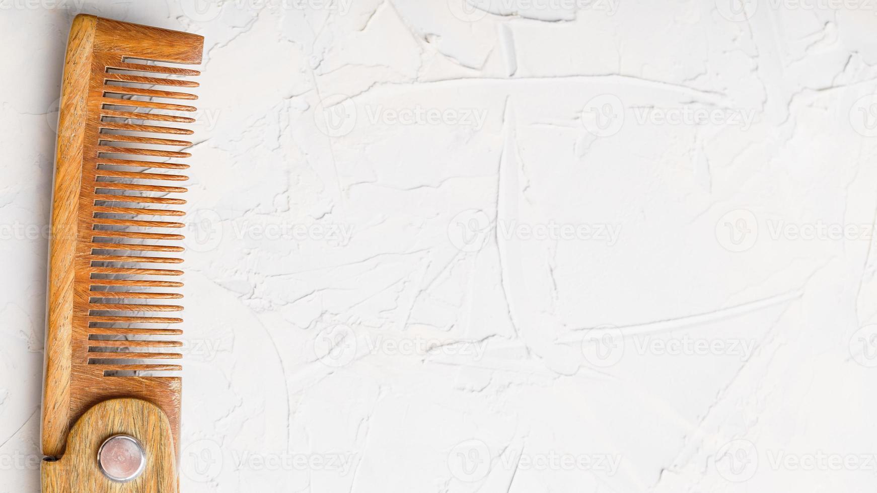 Wooden Sandalwood comb folding on a white textured background. photo