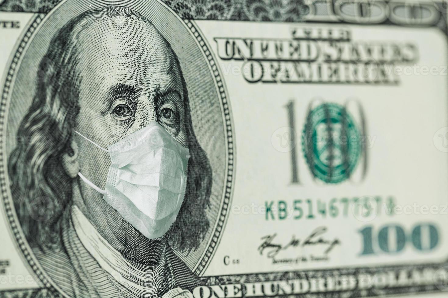 Portrait of Benjamin Franklin 100 dollar Bills with a medical mask from the coronavirus COVID-19. photo