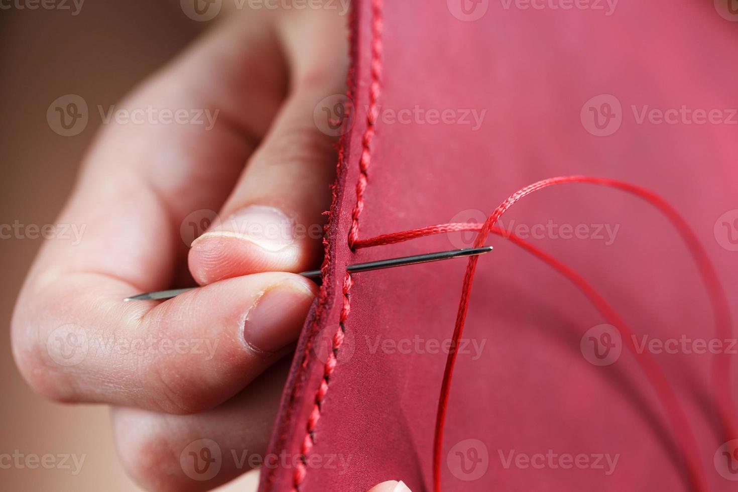 Conceptual profession of a Tanner. The woman's hands closed around the needle and thread. photo