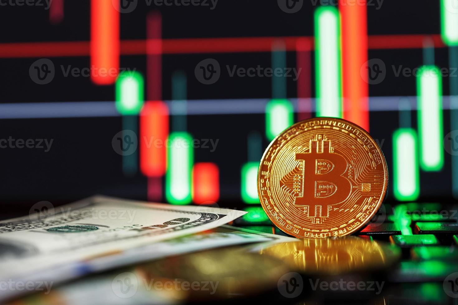 Gold bitcoins on the background of business charts close-up and 100 dollar bills. photo