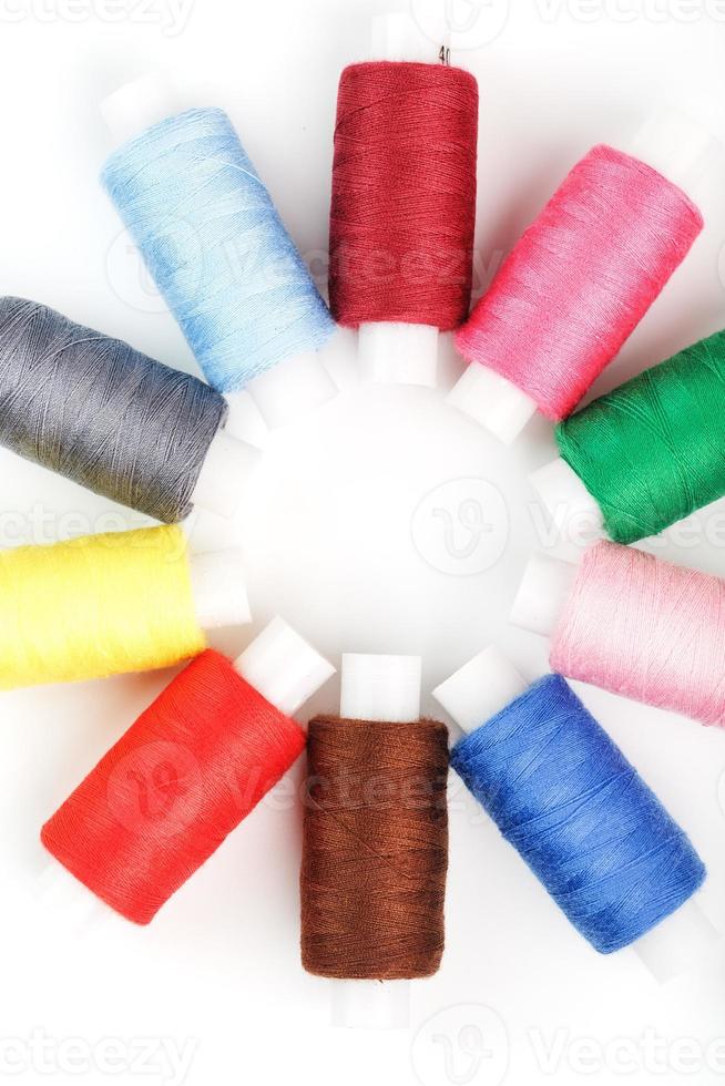 Colorful cotton craft sewing threads in flower shape isolated on white background. photo