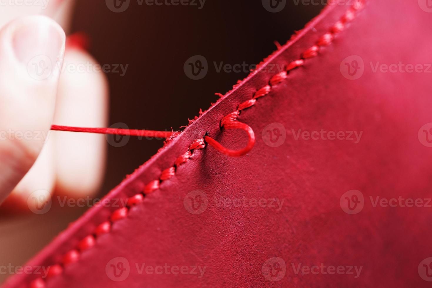 Conceptual profession of a Tanner. The woman's hands closed around the needle and thread. photo