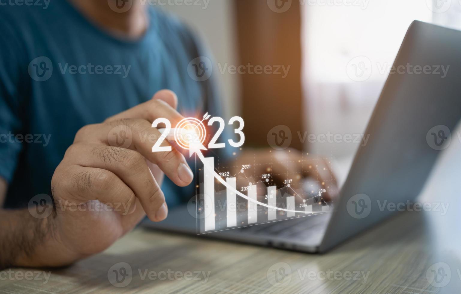 Business man using laptop point digital white pencil on virtual screen goal 2023 trade stocks or crypto currency, funds and cryptocurrencies, invest stock, investors, stock charts. Investment trends. photo