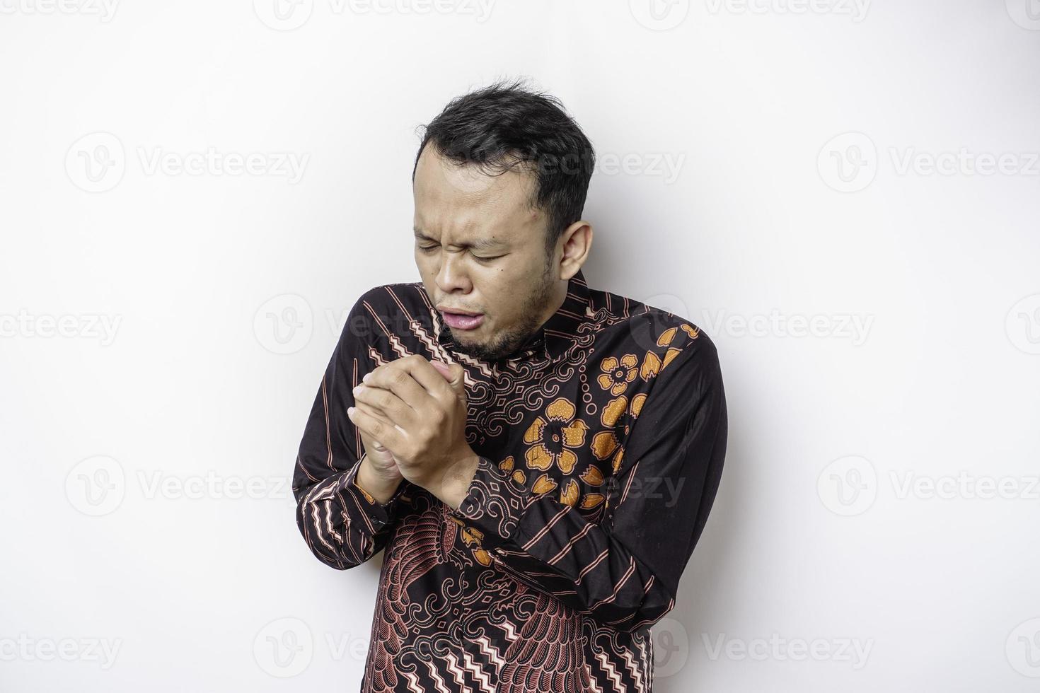 Sick Asian man wearing batik shirt is flu and cough. Illness, influenza, pain concept. Healthcare and Corona Concepts. photo