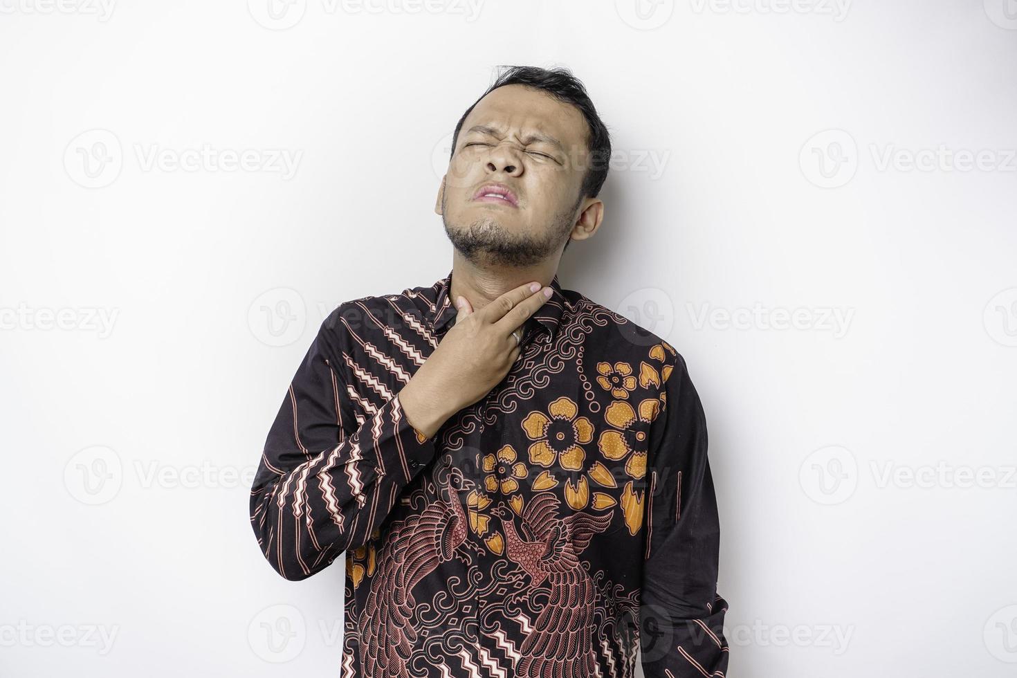 Sick Asian man wearing batik shirt is flu and cough. Illness, influenza, pain concept. Healthcare and Corona Concepts. photo