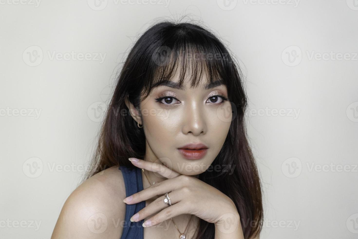 una cara alegre de belleza de una joven modelo asiática con una camiseta verde azulado. maquillaje cuidado de la piel belleza tratamiento facial, spa, concepto de salud femenina. foto