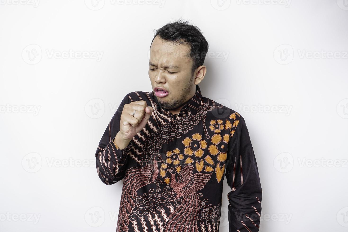 el hombre asiático enfermo que usa camisa batik es gripe y tos. enfermedad, influenza, concepto de dolor. conceptos de salud y corona. foto