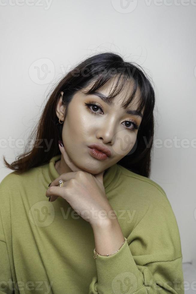 A beauty cheerful face of Asian young model wearing green top. Skincare beauty facial treatment, spa, female health concept. photo