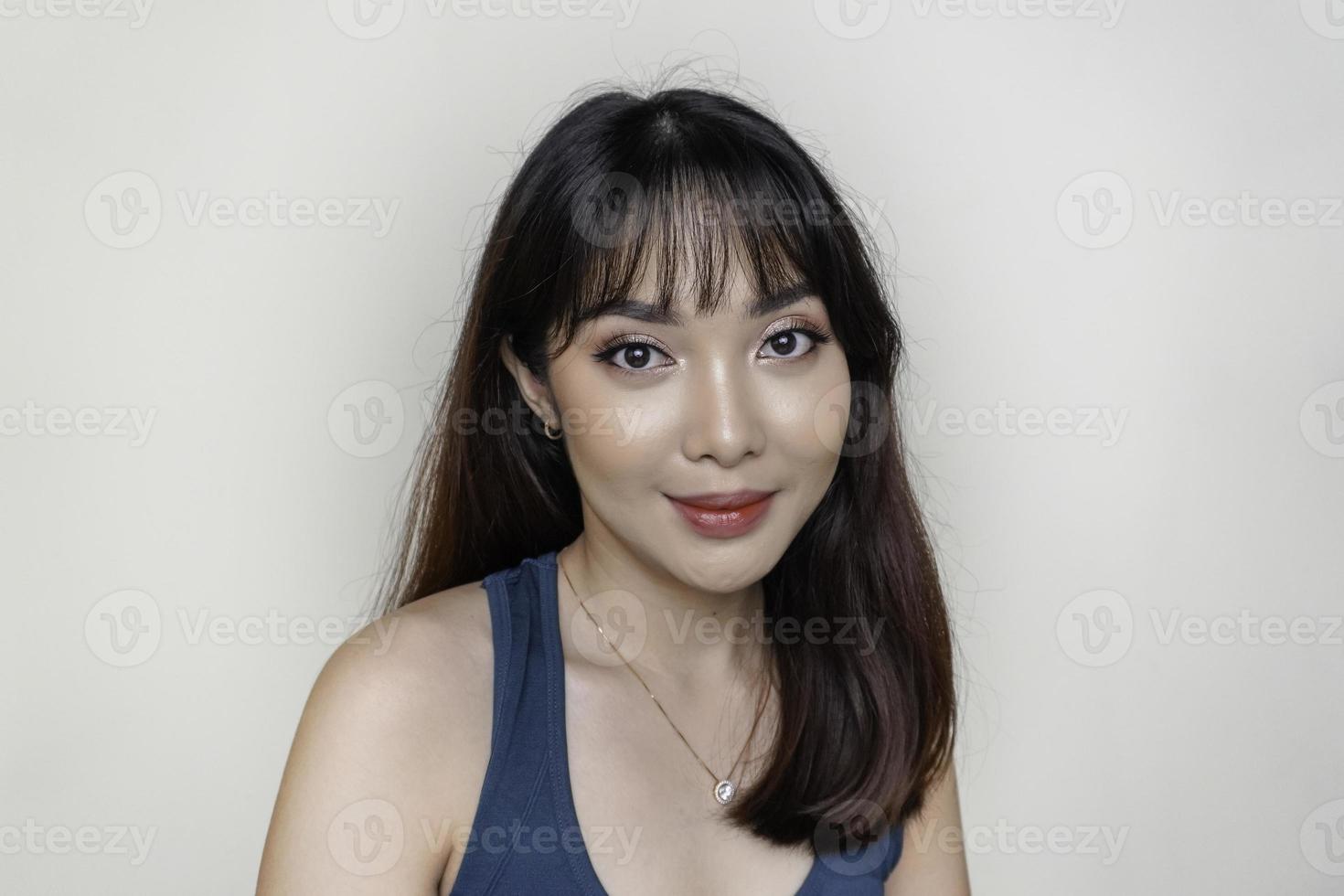 una cara alegre de belleza de una joven modelo asiática con una camiseta verde azulado. maquillaje cuidado de la piel belleza tratamiento facial, spa, concepto de salud femenina. foto