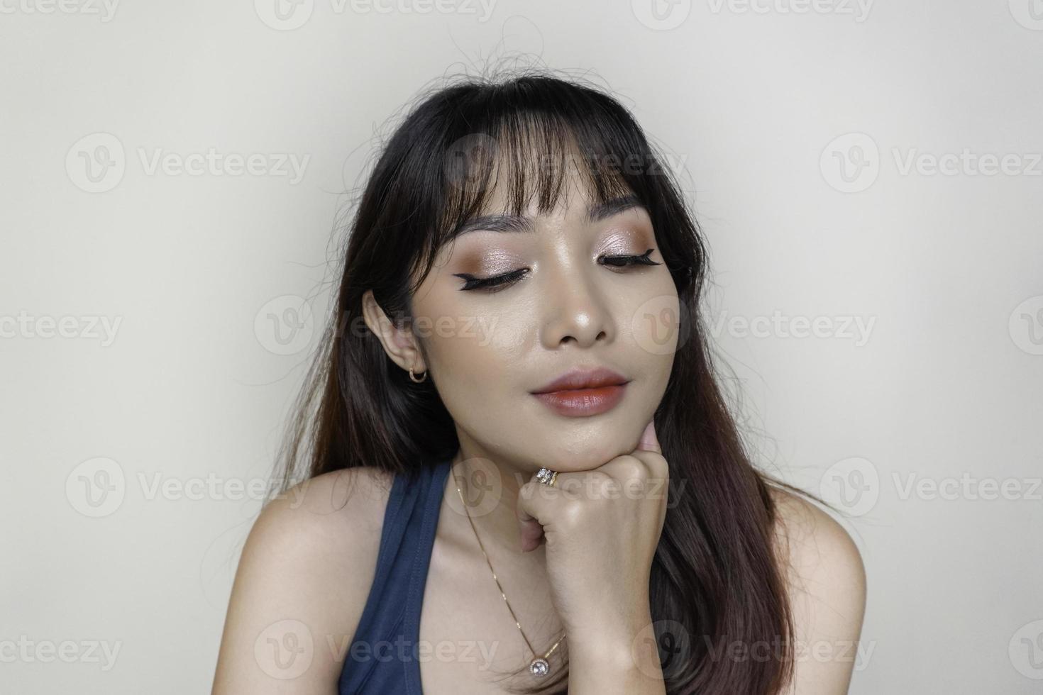 una cara alegre de belleza de una joven modelo asiática con una camiseta verde azulado. maquillaje cuidado de la piel belleza tratamiento facial, spa, concepto de salud femenina. foto