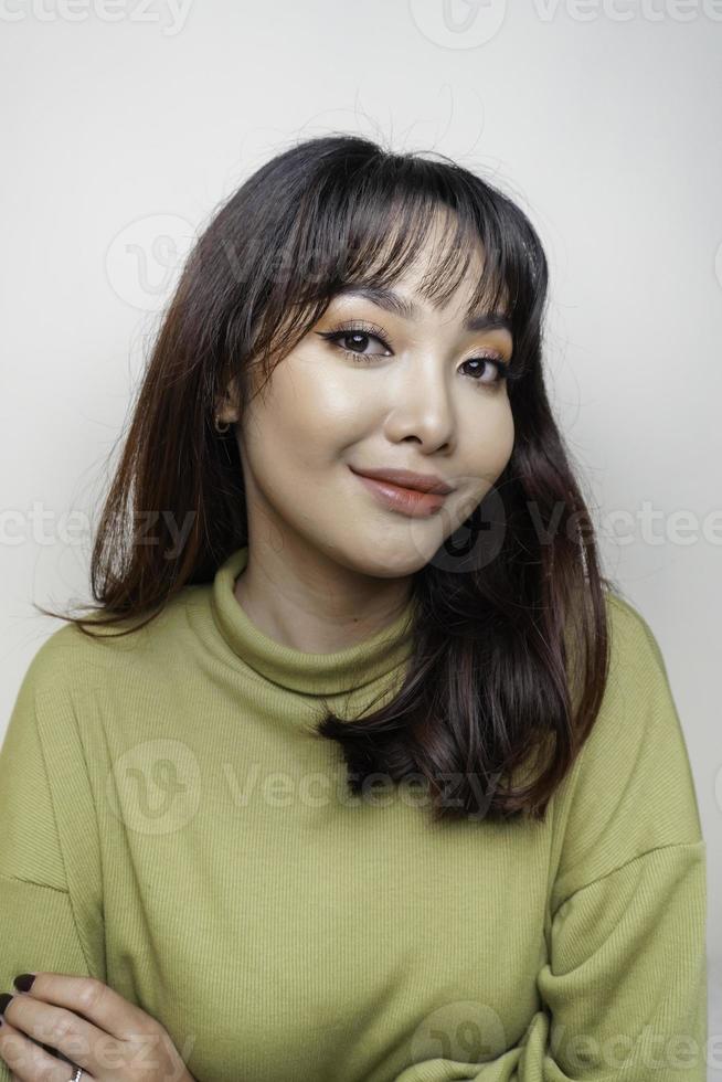 una cara alegre de belleza de una joven modelo asiática con top verde. tratamiento facial de belleza para el cuidado de la piel, spa, concepto de salud femenina. foto