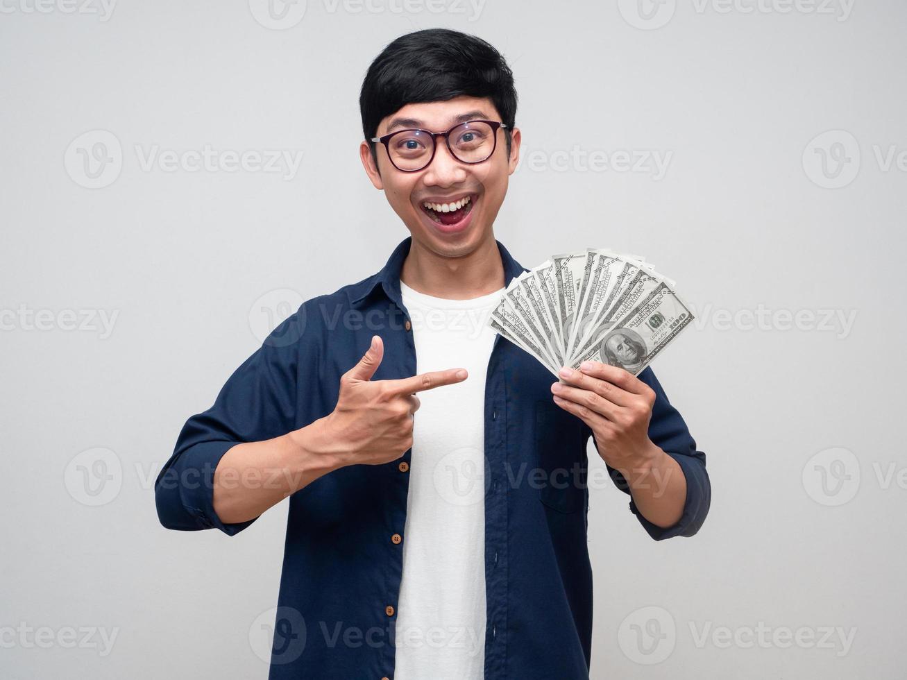 Positive asian man smile and point finger at a lot of money in his hand photo