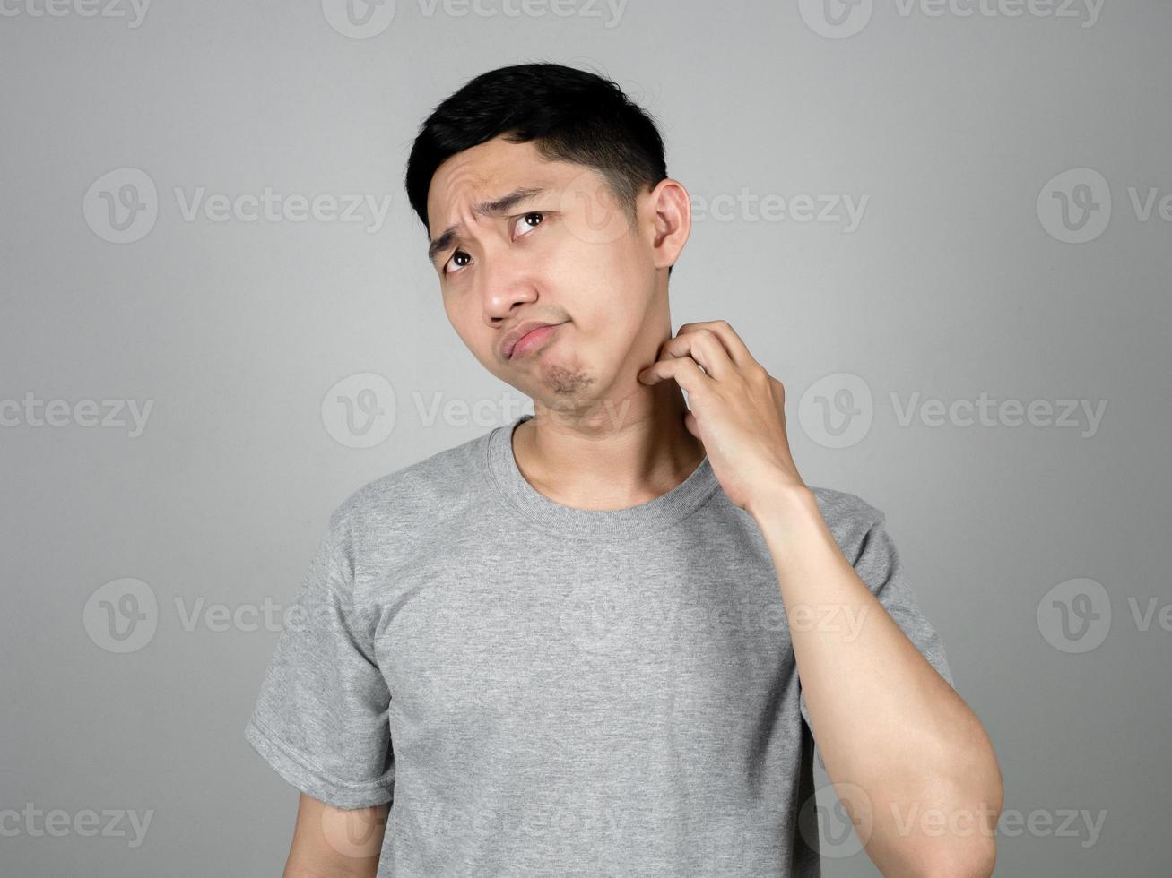 Thai man grey shirt feels worried about skin of his face isolated photo