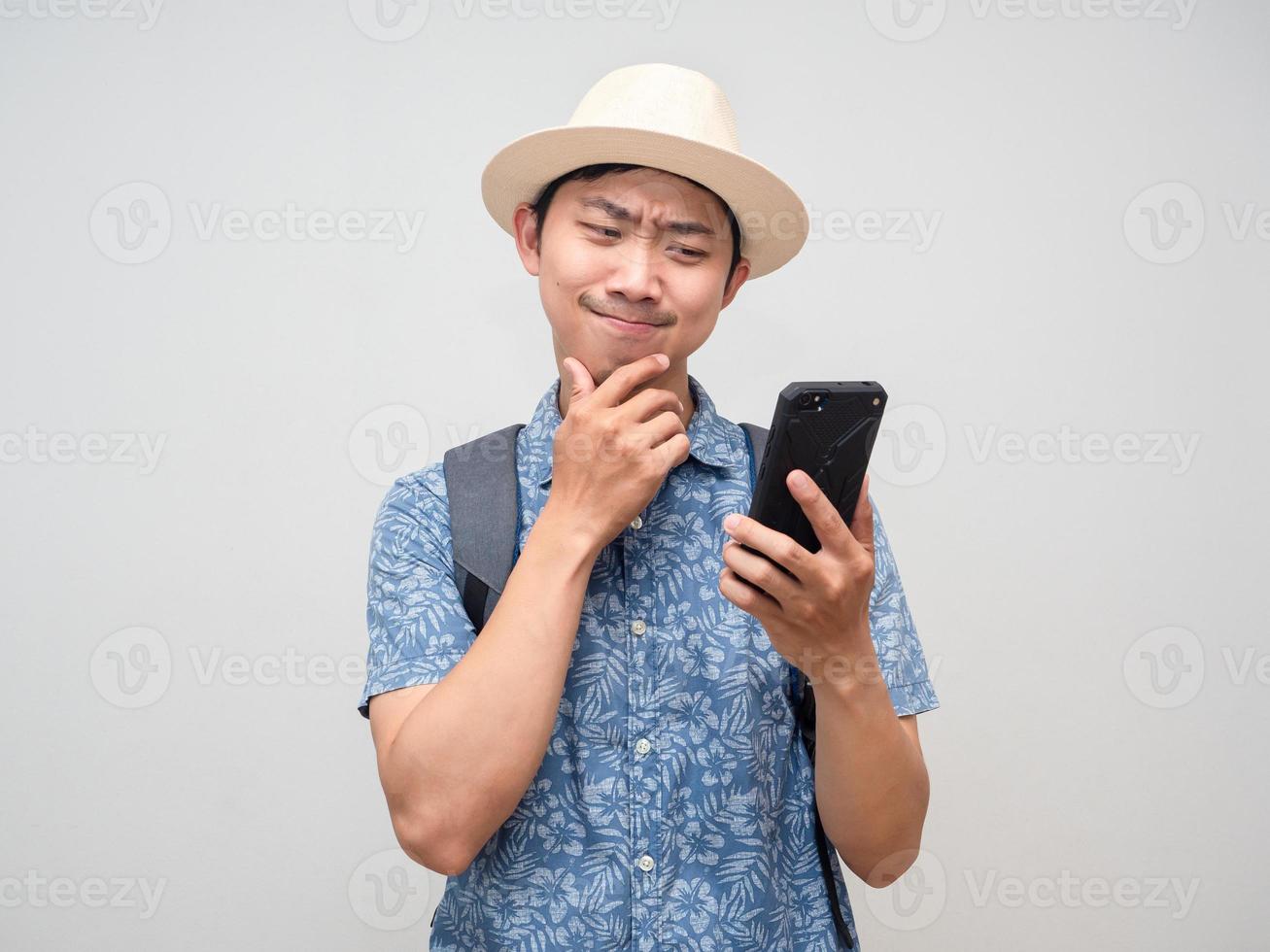 hombre viajero sostenga el teléfono móvil pensando en reservar en vacaciones aislado foto