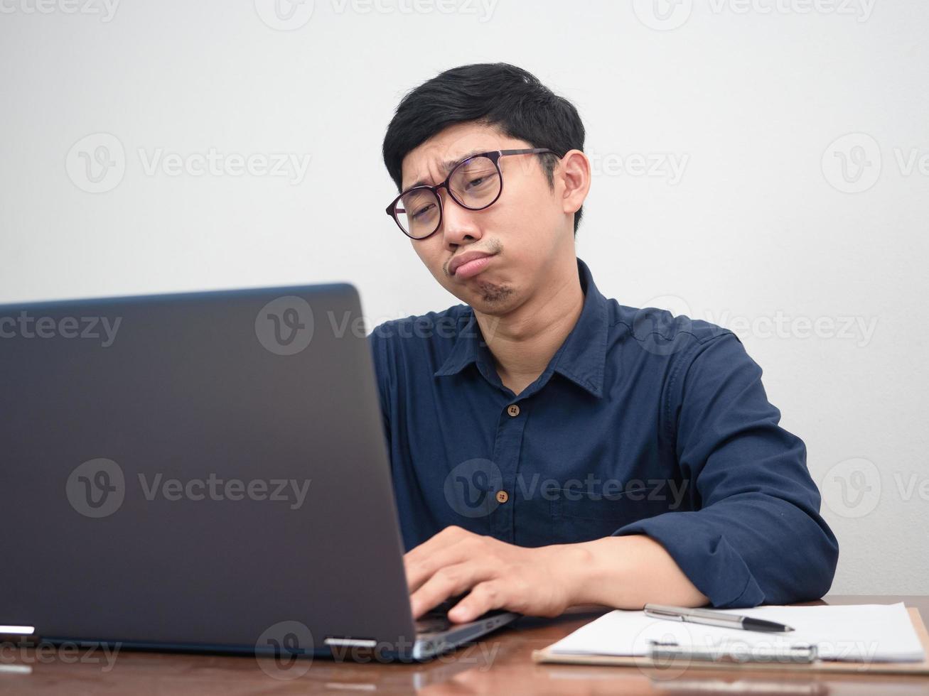 Businessman sitting at working table feels bored and tried about work photo