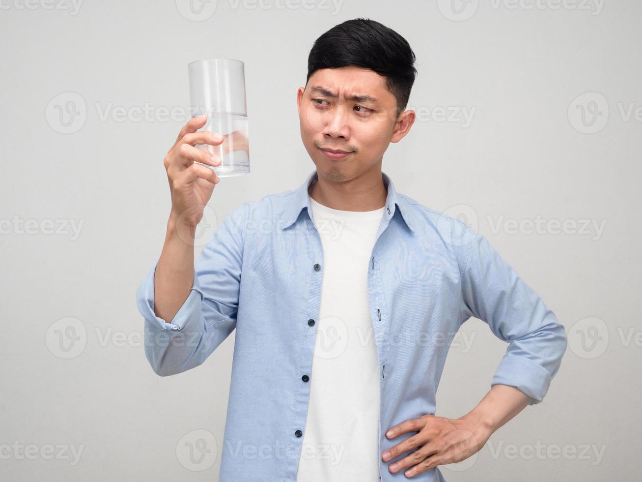 Healthy positive man looking at glass of water in his hand isolated photo