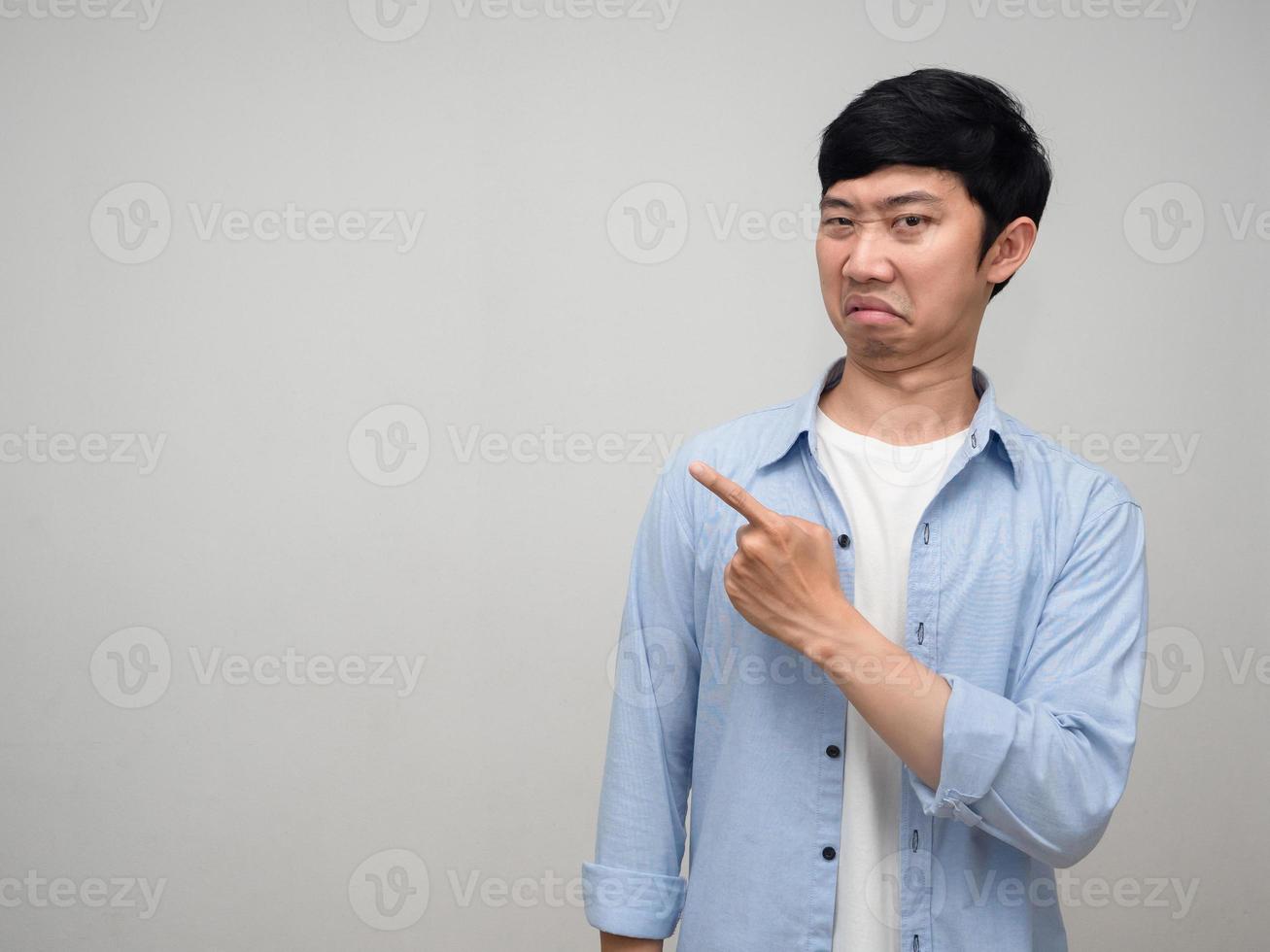 Man blue shirt boring face gesture point finger isolated photo