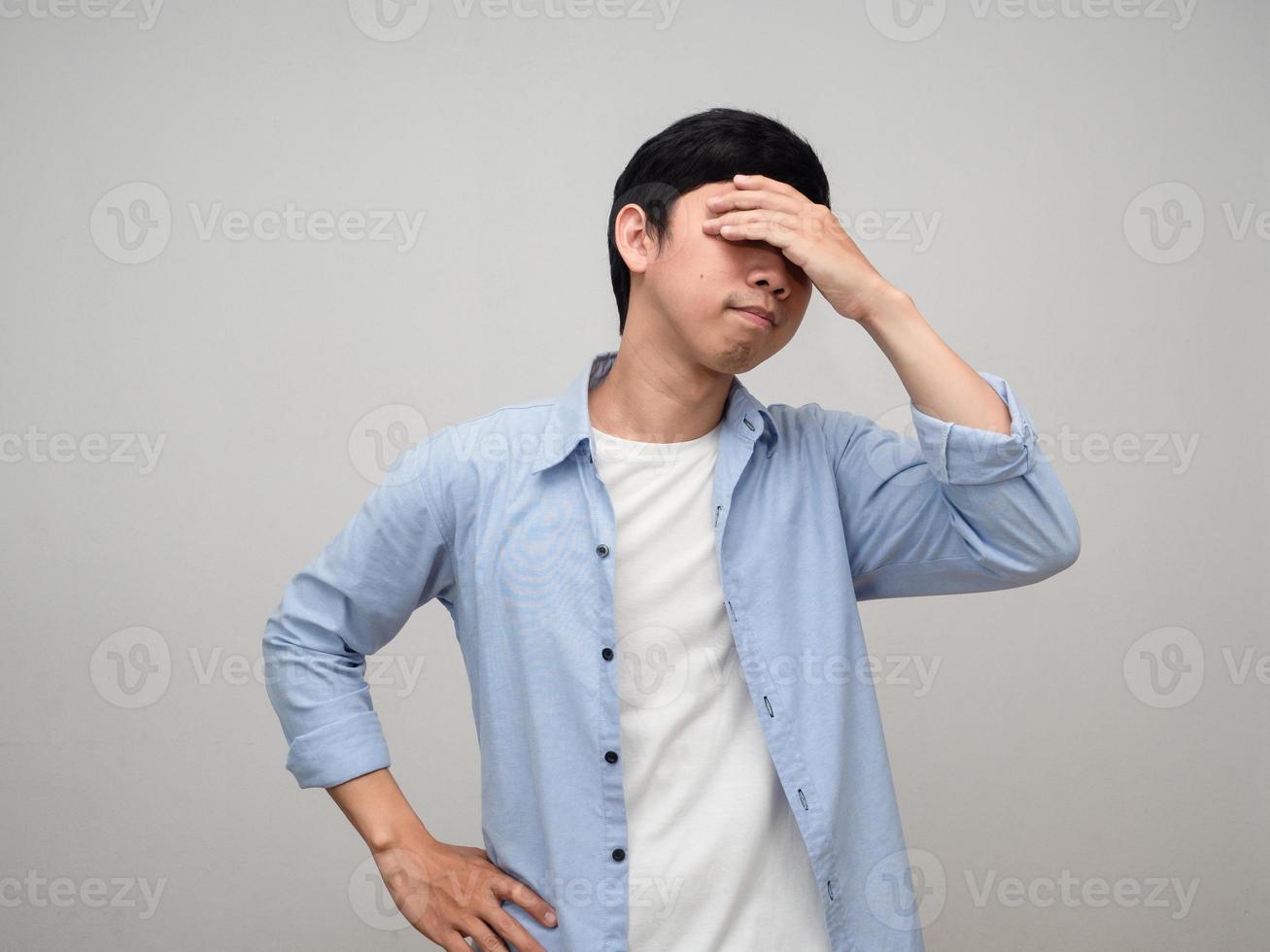 Worker man blue shirt hold his head feels dizzy isolated photo