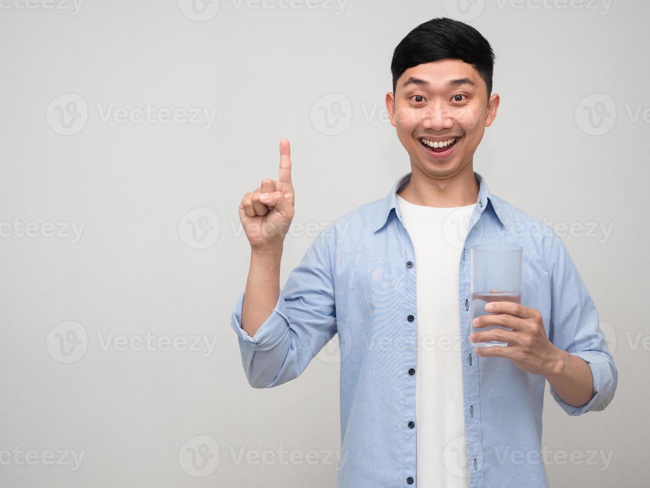 Positive asian man happy smile giving glass of water gesture point finger up isolated photo