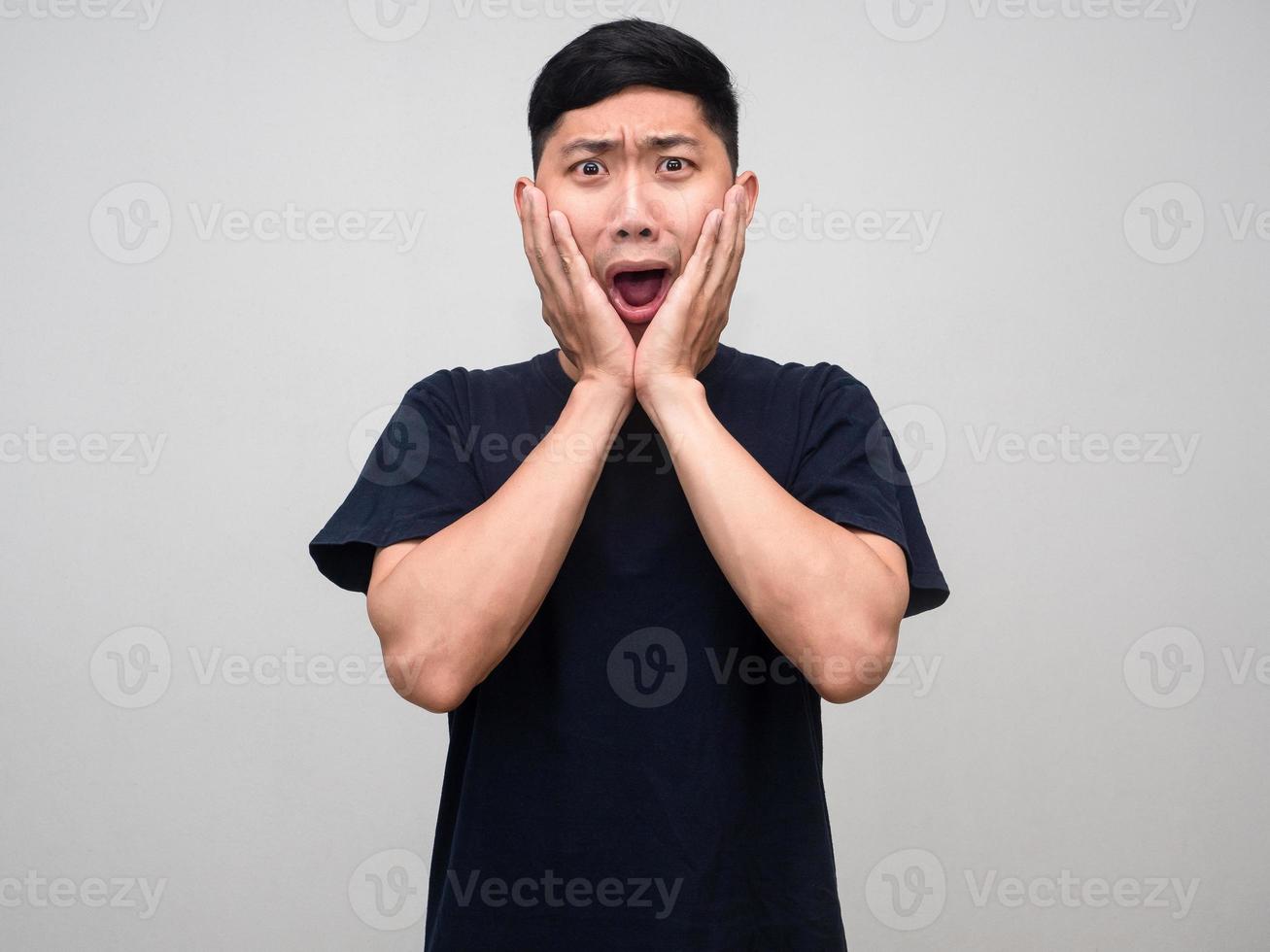 Asian man black shirt gesture surprised shocked at his face isolated photo