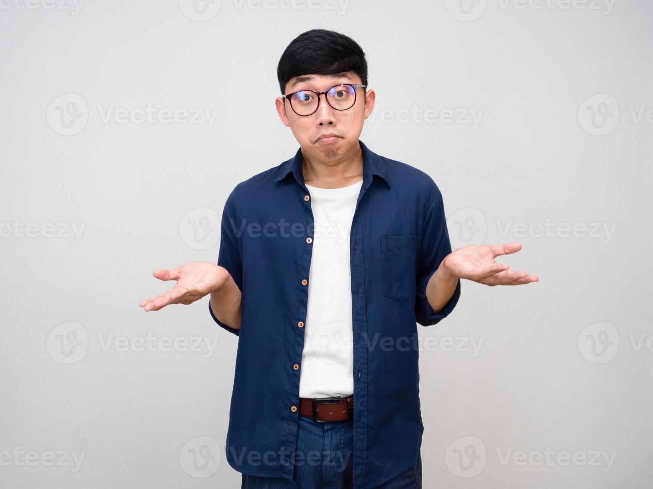 Young asian man wear glasses gesture confused show hands up isolated photo