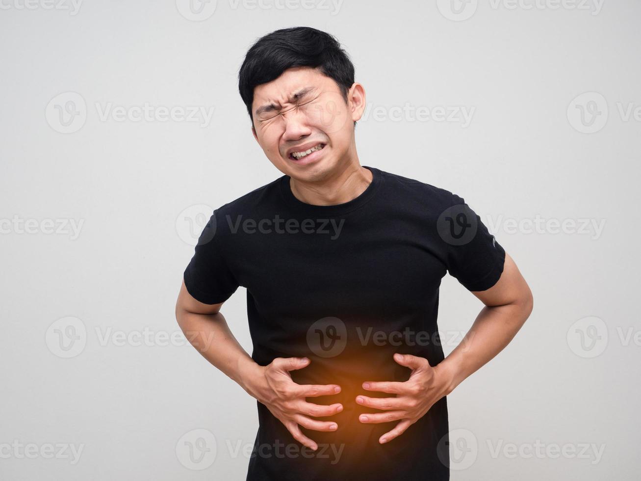 el hombre asiático sostiene su vientre siente mucho dolor de estómago aislado foto