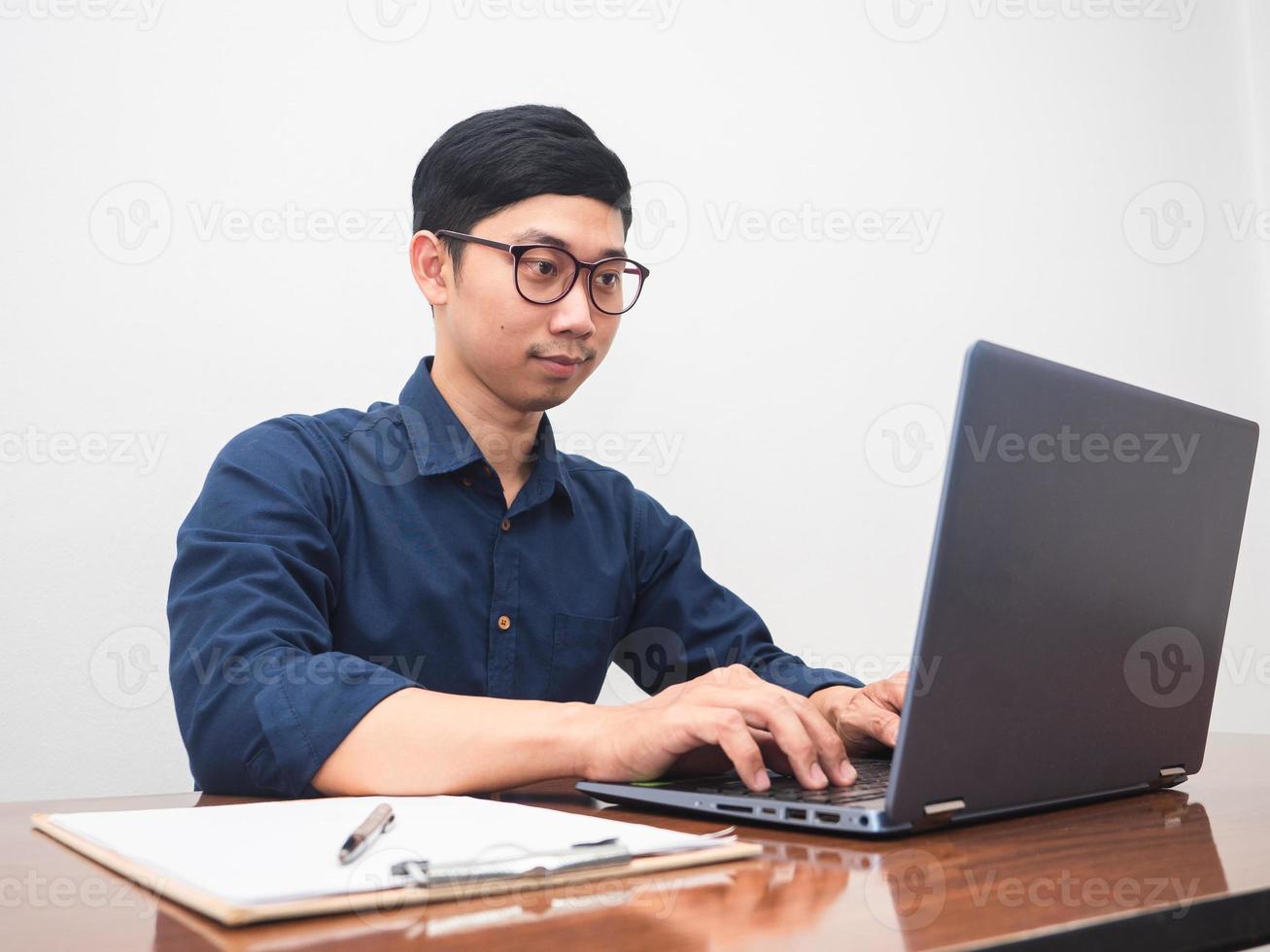 Businessman using laptop at workplace table in the room photo