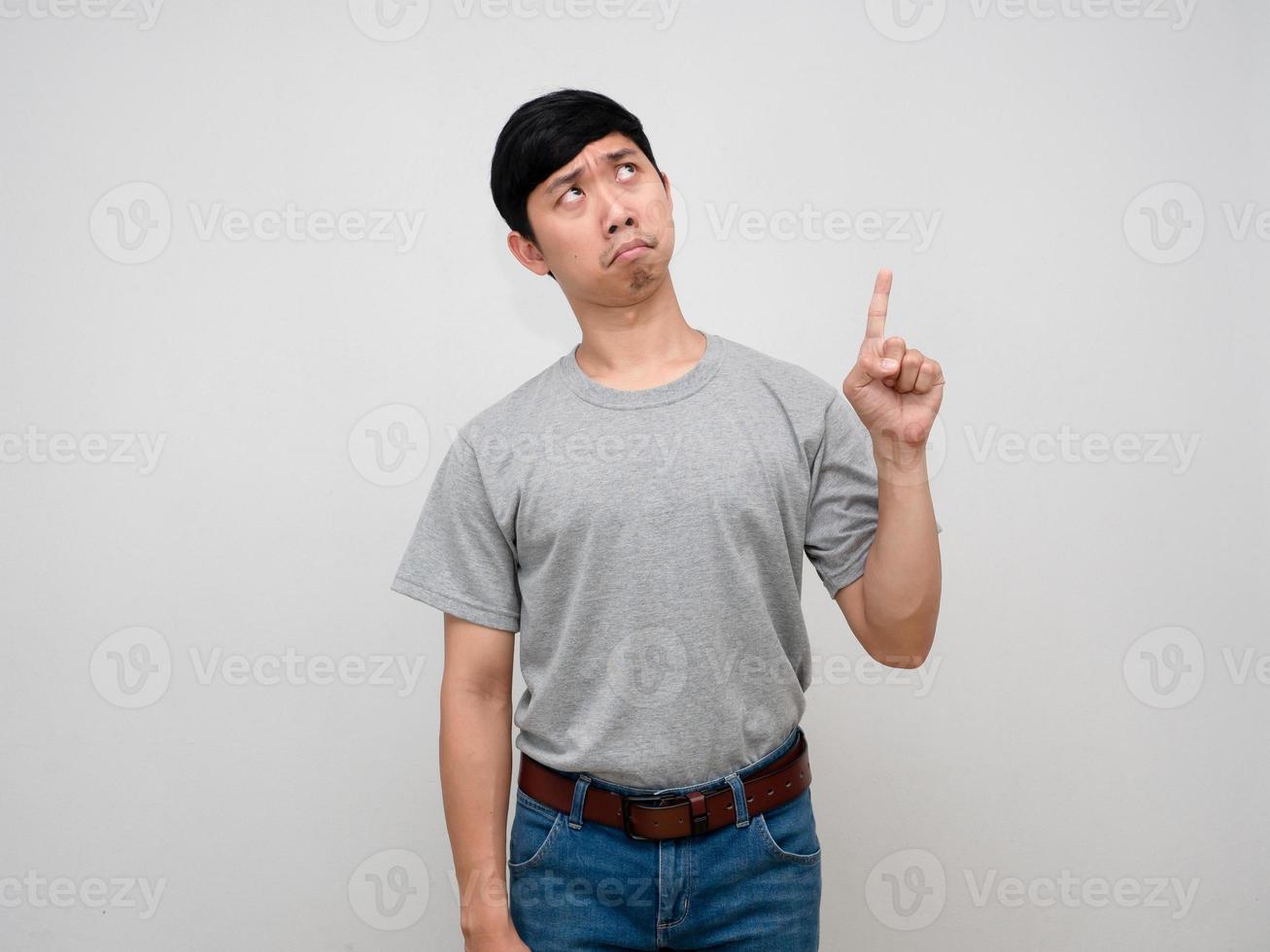 Asian man grey shirt standing point finger above feels worried isolatd photo