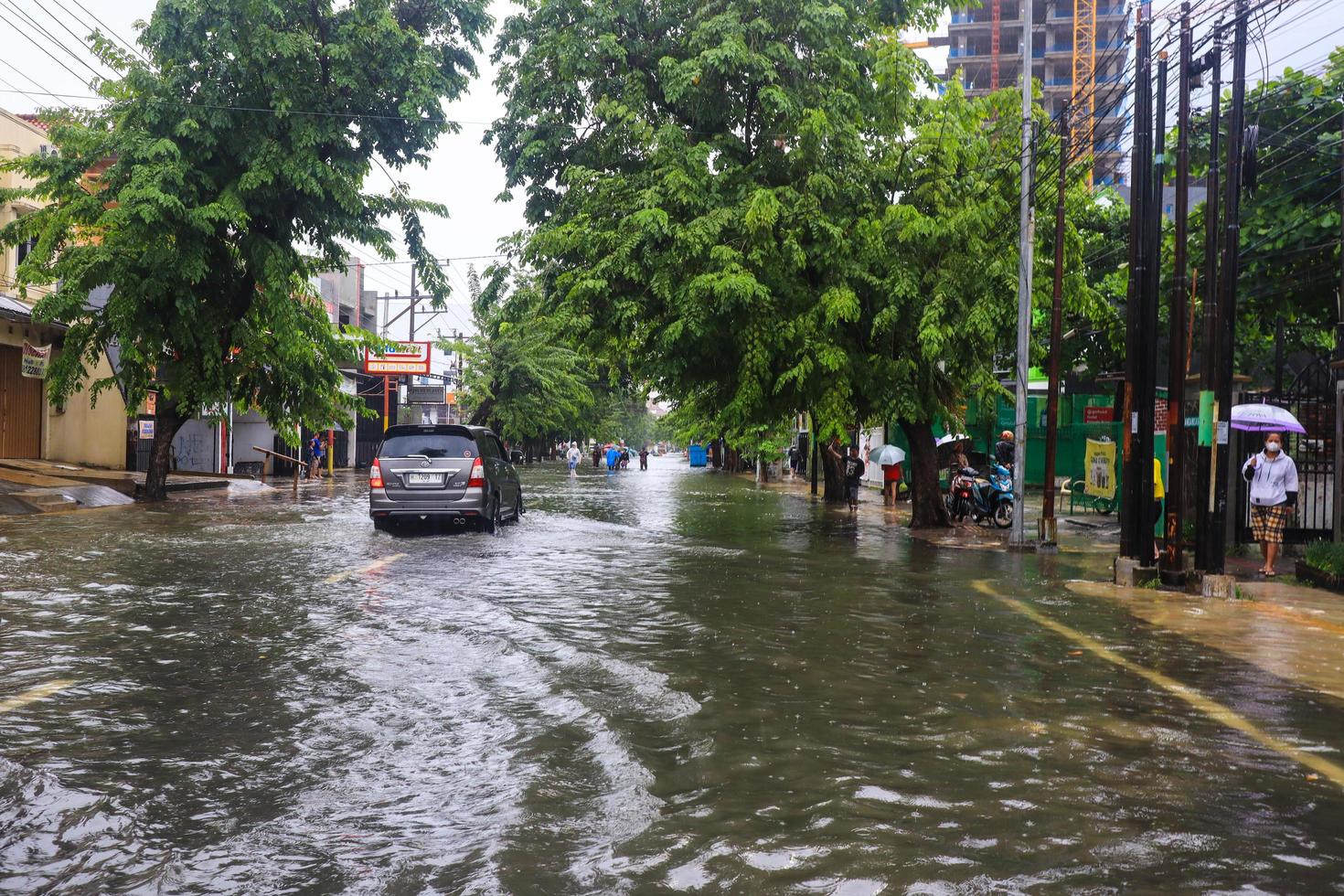 Semarang, December 2022. Some people are walking through the flood that hit the Poncol train station area and some residents are preparing to evacuate. vehicles hit the flood photo