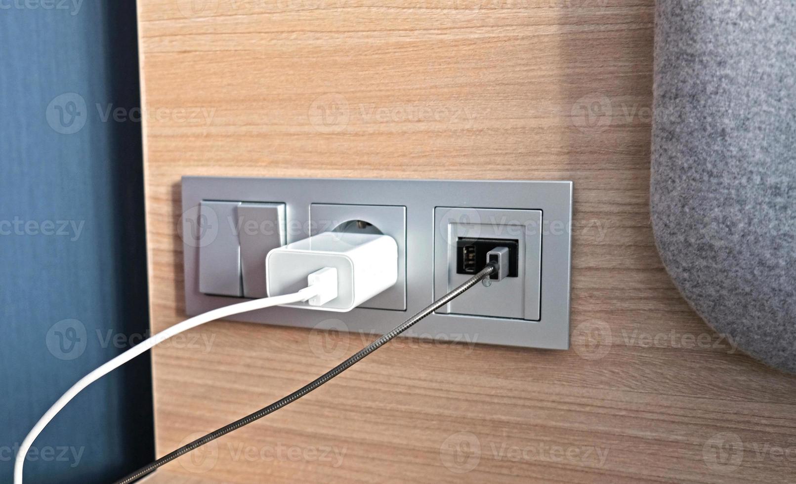 Electrical power socket, usb socket, light switch on the wood panel in the interior of the hotel. For convenience, the mobile charger or smartphone in the concept of modern life. Close up. photo