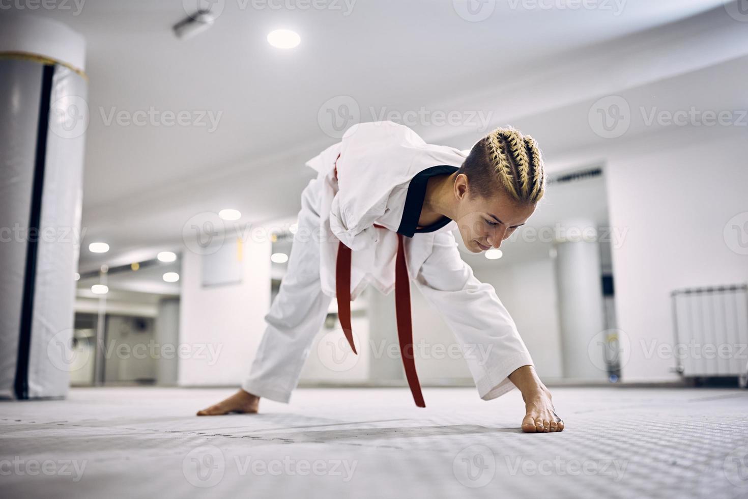 Disabled taekwondoin warming up while practicing in martial arts club. photo