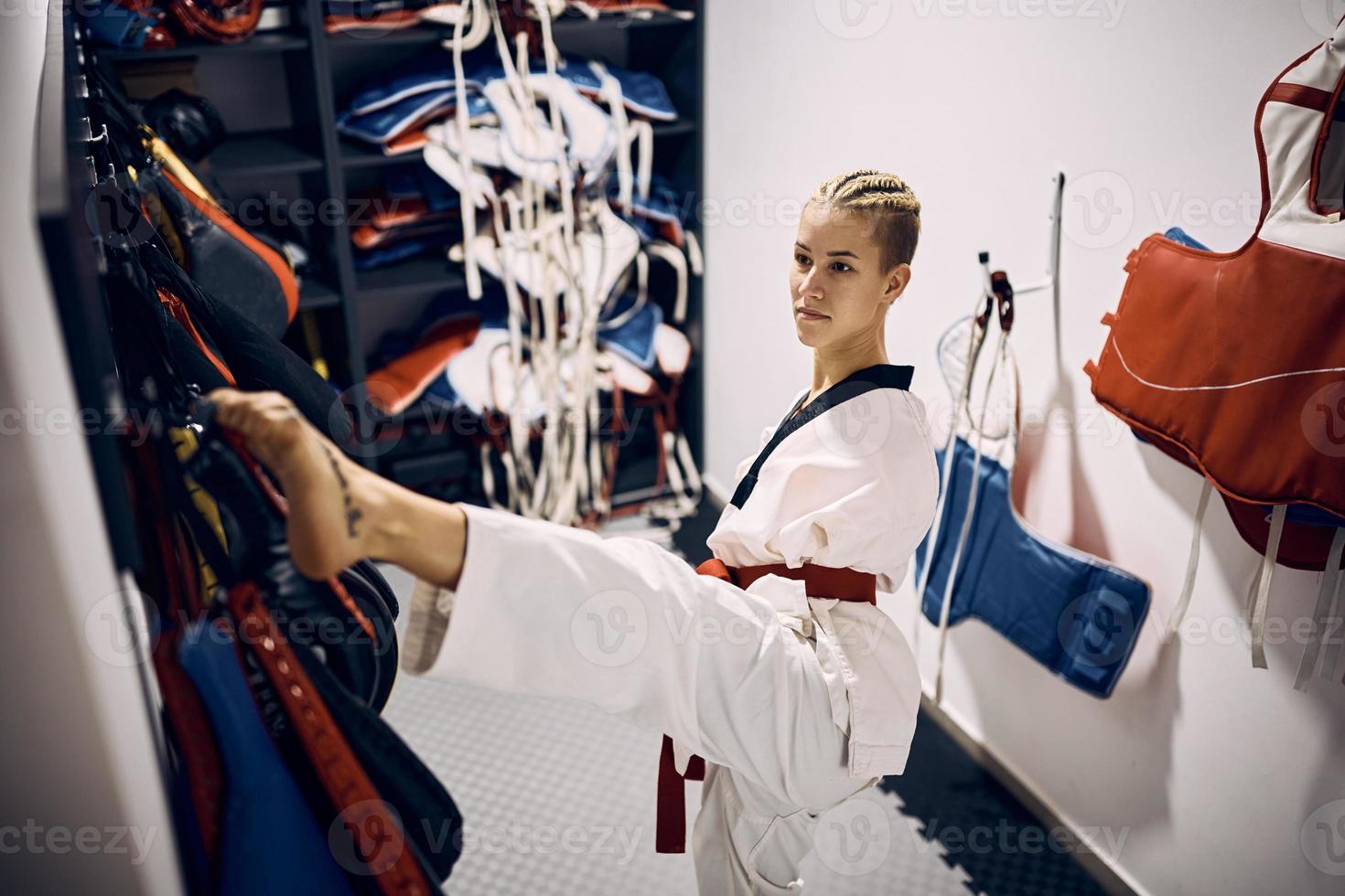 Female martial artist with disability dressing up in locker room at health club. photo